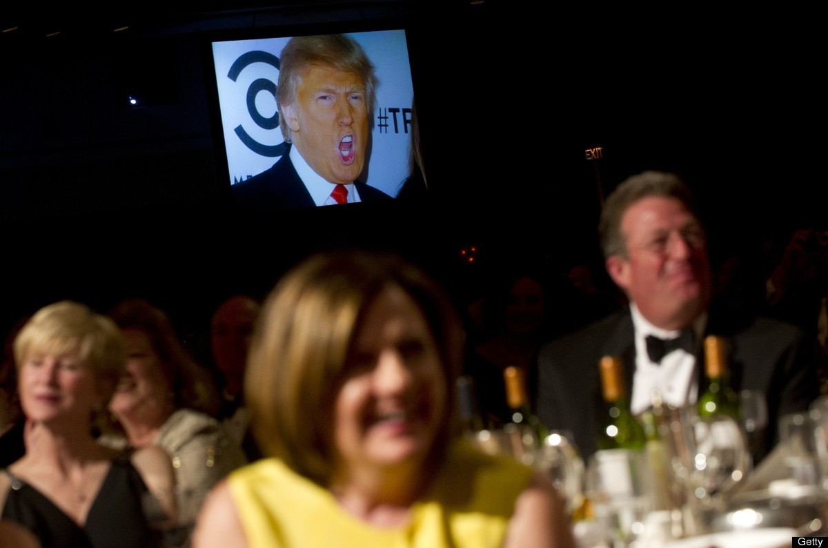 A picture of Donald Trump appears on a screen as US President Barack Obama tells a joke during the White House Correspondents