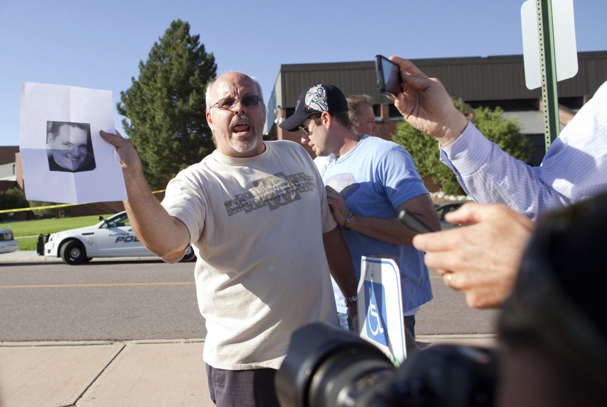 Tom Sullivan , holds a photograph of his son, Alex Sullivan, as he pleads with the media to help him find his son, outside Ga