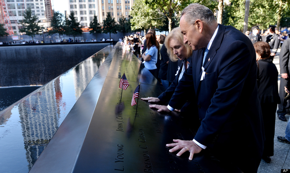 U.S Senators Kirsten Gillibrand, and Charles Schumer, D-NY, place American flags in names engraved in the border of one of th