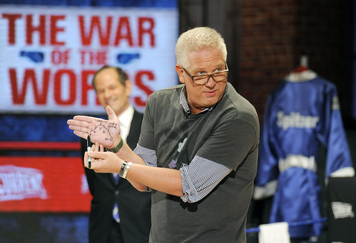 In this photo provided by DISH, Glenn Beck, right, shows a diagram on his hand as he and Gov. Eliot Spitzer, left, square off