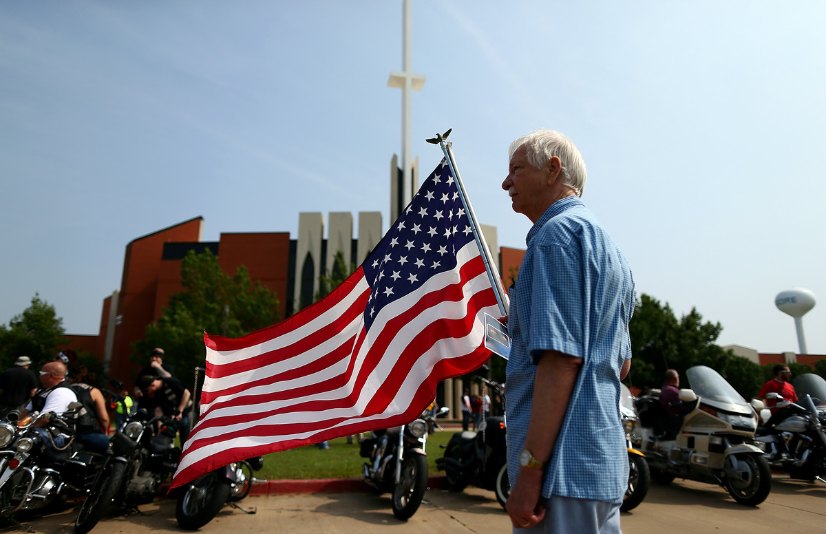MOORE, OK - MAY 24:  Larry Cory displays an American flag outside the funeral for nine-year-old tornado victim Nicholas McCab