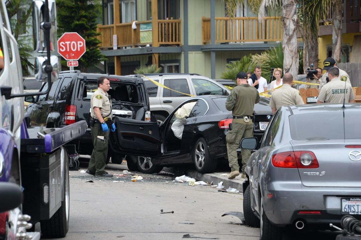 Investigators inspect a suspected gunman's car on May 24, 2014, after a drive-by shooting in Isla Vista, California, a beach 