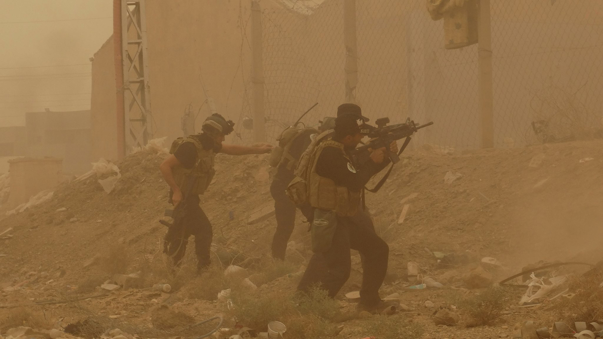 Security forces defend their headquarters against attacks by Islamic State extremists during sand storm in the eastern part o