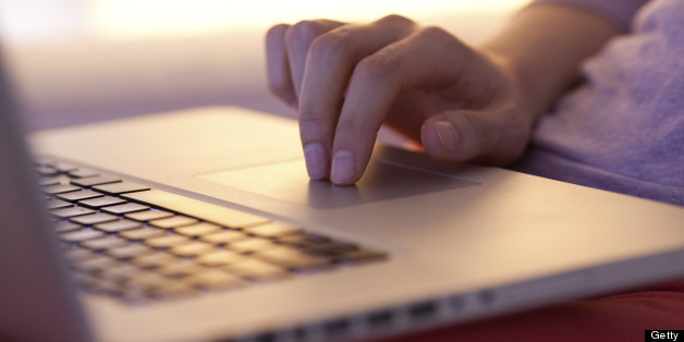 Close up of a female hand touching touch pad of a laptop.