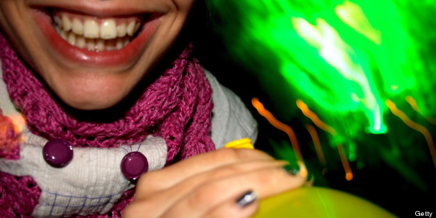 Detail of someone smiling and holding a laughing gas balloon. (Photo by Universal Images Group via Getty Images)