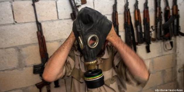 Un rebelle syrien passe un masque à gaz, dans la province d'Idlib, le 18 juillet 2013