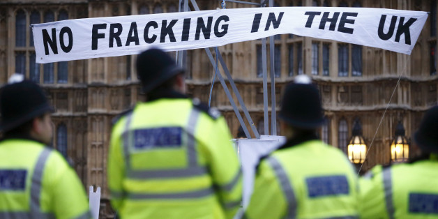 British police secure the area where demonstrators erected a mock fracking rig with a banner reading 'No fracking in the UK' in a protest against hydraulic fracturing for shale gas outside the Houses of Parliament in London on December 1, 2012. The demonstration organised by various groups protested against any expansion into Britain of the pratcice of 'hydraulic fracturing' or 'fracking' for shale gas which the Campaign Against Climate Change group, one of the organisations involved in the acti