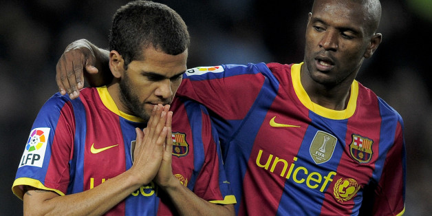 Barcelona's Brazilian defender Daniel Alves (L) is congratuled by his teammate French defender Eric Abidal (R) after scoring during a Spanish League football match against Sevilla at the Camp Nou Stadium in Barcelona , on October 30, 2010. AFP PHOTO / JOSEP LAGO (Photo credit should read JOSEP LAGO/AFP/Getty Images)