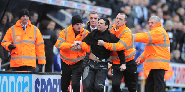 NEWCASTLE UPON TYNE, ENGLAND - FEBRUARY 01: A disgruntled Newcastle fan waving his season ticket is removed from the pitch by stewards during the Barclays Premier League match between Newcastle United and Sunderland at St James' Park on February 1, 2014 in Newcastle upon Tyne, England. (Photo by Chris Brunskill/Getty Images)
