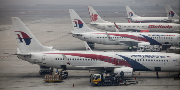 Aircraft operated by Malaysian Airline System Bhd. (MAS) and PT Lion Mentari Airlines (Lion Air) stand shrouded in haze at Kuala Lumpur International Airport (KLIA) in Sepang, Malaysia, on Friday, March 14, 2014. Indian forces expanded the search for missing Malaysian Airlines Flight 370 to the Bay of Bengal after evidence mounted the plane with 239 people on board may have flown long after controllers lost contact with it a week ago. Photographer: Charles Pertwee/Bloomberg via Getty Images