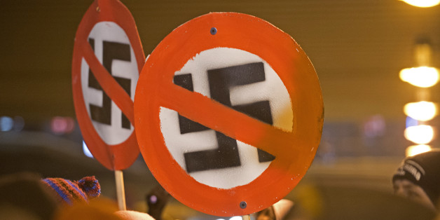 Left-wing demonstrators hold a sign with a crossed out swastika to protest against a far-right march marking the 67th anniversary of the allied bombings during World War II in Dresden, eastern Germany, on February 13, 2013. A massive bombing raid by Allied forces on Dresden beginning on February 13, 1945 sparked a firestorm that destroyed much of the historical centre of the city. AFP PHOTO / ROBERT MICHAEL (Photo credit should read ROBERT MICHAEL/AFP/Getty Images)