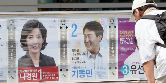 7·30재보궐 선거운동이 시작된 17일 서울 동작구 중앙대 정문 인근에서 한 유권자가 동작을 국회의원 후보자들의 선거벽보를 유심히 살펴보고 있다.ⓒ연합뉴스