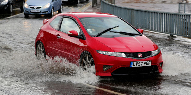 Cars pass through a flash flood following a heavy rain shower in Maidstone, Kent.
