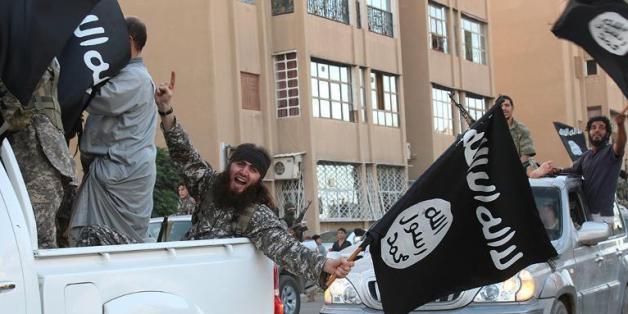 mage extraite du média jihadiste Al-Baraka news, le 11 juin 2014, montrant des militants de l'EI et leur drapeau noir dans la ville syrienne de Raga