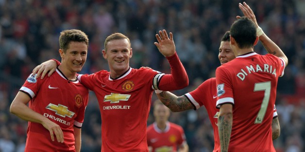 Manchester United's English striker Wayne Rooney (2nd L) celebrates scoring their third goal with teammates during the English Premier League football match between Manchester United and Queens Park Rangers at Old Trafford in Manchester, north west England on September 14, 2014. AFP PHOTO/PAUL ELLIS
RESTRICTED TO EDITORIAL USE. No use with unauthorized audio, video, data, fixture lists, club/league logos or live services. Online in-match use limited to 45 images, no video emulation. No use in betting, games or single club/league/player publications. (Photo credit should read PAUL ELLIS/AFP/Getty Images)