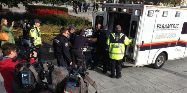 Ambulanciers et policiers s'occupent d'une personne blessée par des tirs au Mémorial de la Guerre à Ottawa (Canada) le 22 octobre 2014