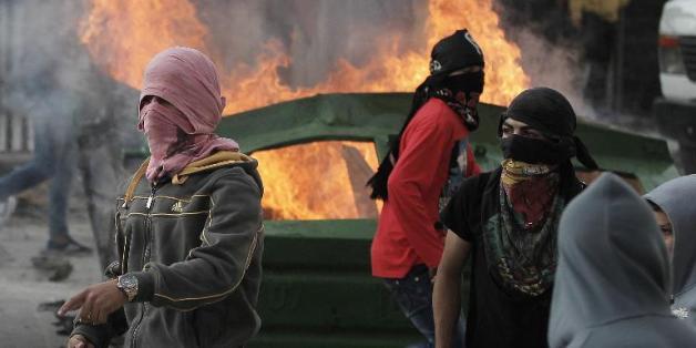 Des jeunes Palestiniens masqués lors de heurts avec des policiers israéliens au amp de Chouafat, à Jérusalem-Est, le 5 novembre 2014