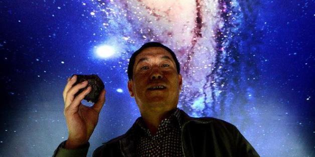 Tong Xianping montre une météorite le 19 septembre 2014 dans son espace d'exposition à Urumqi, capitale de la vaste région désertique du Xinjiang, dans l'ouest de la Chine