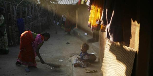 Une femme passe le balai devant son domicile dans l'Etat de Chhattisgarh, dans le centre de l'Inde
