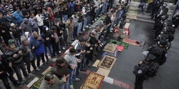 Des forces de sécurité israéliennes face à un groupe de Palestiniens participant à la prière du vendredi dans une rue de Jérusalem-Est, le 31 octobre 2014.