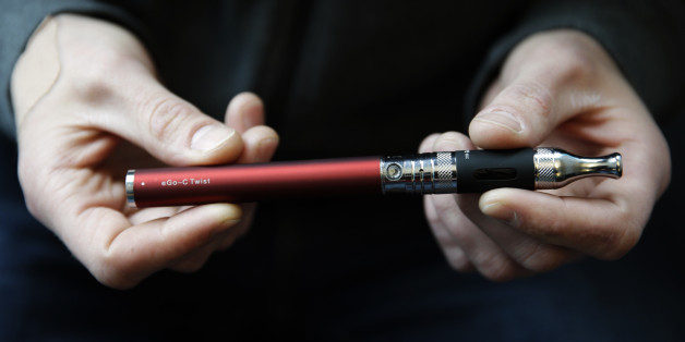Eric Scheman holds an e-cigarette at Vape store in Chicago, Wednesday, April 23, 2014. The federal government wants to ban sales of electronic cigarettes to minors and require approval for new products and health warning labels under regulations being proposed by the Food and Drug Administration. (AP Photo/Nam Y. Huh)