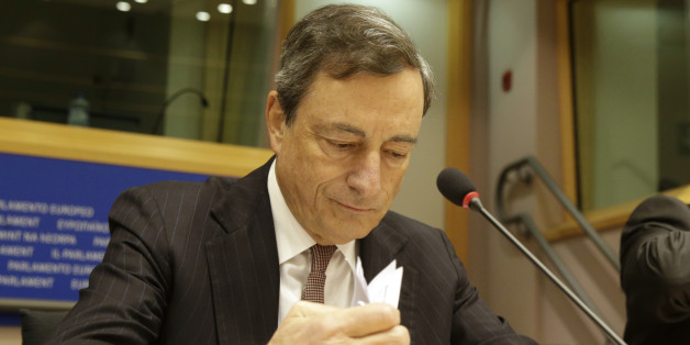 President of the European Central Bank Mario Draghi checks his papers prior to address the Committee on Economic and Monetary Affairs, at the European Parliament building, in Brussels on Monday, Nov. 17, 2014. (AP Photo/Yves Logghe)