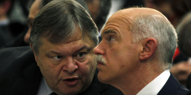 Greeces' Finance Minister Evangelos Venizelos, left, speaks to former Greek Prime Minister George Papandreou during a conference of PASOK socialist party at Faliro near Athens, Saturday, March 10, 2012. Greece's private creditors agreed Friday to take cents on the euro in the biggest debt writedown in history, paving the way for an enormous second bailout for the country to keep Europe's economy from being dragged further into chaos. (AP Photo/Kostas Tsironis)