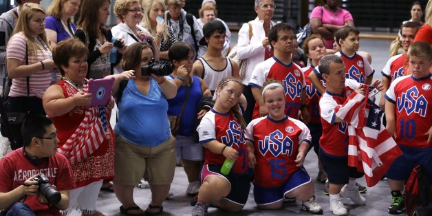 In an Aug. 8, 2013 photo, family members and supporters photograph the volleyball medal ceremony after competition at the 2013 World Dwarf Games in East Lansing, Mich. The quadrennial multi-sport competition for dwarf athletes features more than 500 athletes from 25 nations. Dwarfism is defined as an adult height of 5 feet for those with a disproportionate dysplasia, and 4-foot-10 for those with a proportionate short stature due to medical reasons. (AP Photo/Carlos Osorio)