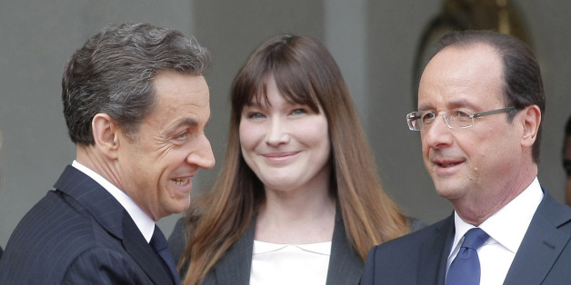 FILE - This May 15, 2012 photo from files shows the then new French President, Francois Hollande, right, shaking hand with outgoing President Nicolas Sarkozy while Hollande's companion Valerie Trierweiler, behind left, and Carla Bruni-Sarkozy, behind center, look on, after the handover ceremony at the Elysee Palace in Paris. Former French First Lady Carla Bruni says she thinks her unmarried successor Valerie Trierweiler should get hitched to be taken more seriously. (AP Photo/Thibault Camus, File)