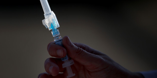 SAN PABLO, CA - NOVEMBER 06: A nurse holds a syringe filled with flu vaccine during a drive-thru flu shot clinic at Doctors Medical Center on November 6, 2014 in San Pablo, California. Doctors Medical Center hosted a drive-thru flu shot clinic offering free vaccines for any community member over the age of 18. (Photo by Justin Sullivan/Getty Images)