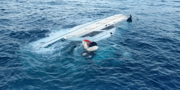 In this photo released by the Hellenic Coast Guard, a yacht used to transport immigrants illegally that overturned in a fatal accident is seen near the Greek island of Samos, on Monday, May 5, 2014. At least 22 people drowned in the incident in the eastern Aegean Sea, while 36 were rescued and others remain missing. Coast guard officials recovered the bodies of two women, a man and a boy from the sea, and later found a further 18 bodies, including three children, inside the yacht after it was t
