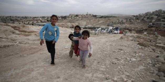 Des enfants bédouins pieds nus courent sur un chemin, le 22 octobre 2014 aux environs de Jérusalem