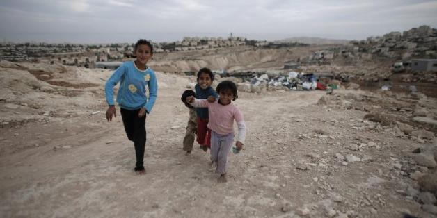 Des enfants bédouins pieds nus courent sur un chemin, le 22 octobre 2014 aux environs de Jérusalem