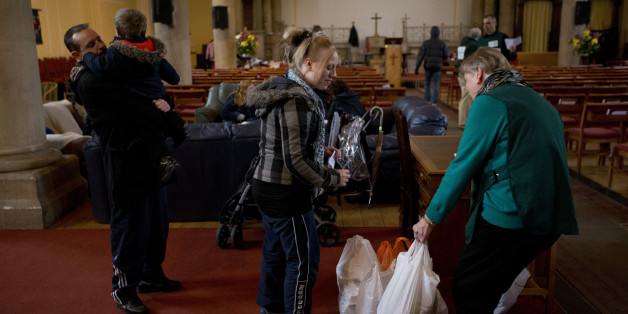 In this photo taken Friday, April 5, 2013, a volunteer, right, gives bags of food to Natalie Cribbin, center, at a food bank in St Luke's Church in the West Norwood area of London. Itâs possible that official figures on first quarter economic growth, to be released Thursday, could put the country back in recession. It would take the smallest statistical variation to put the figure in negative territory which would place the country in recession, another recession _ the third since the 2008 financial crisis _ and is already being referred to with foreboding in the media as a âTriple Dip". (AP Photo/Matt Dunham)