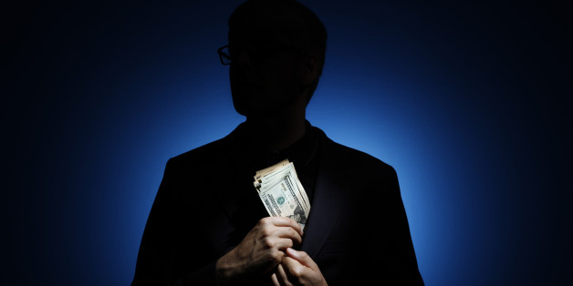 BERLIN, GERMANY - AUGUST 06: Silhouette of a man who puts a large bundle of banknotes in his jacket on August 06, 2014, in Berlin, Germany. (Photo by Thomas Trutschel/Photothek via Getty Images)***Local Caption***