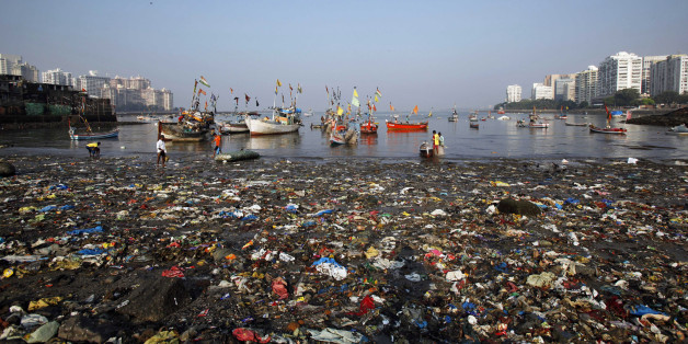 Indian men work near plastic and other waste at seashore near Colaba in Mumbai, India, Sunday, Nov. 4, 2012. (AP Photo/Rajesh Kumar Singh)