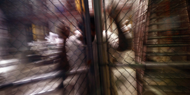 GUANTANAMO BAY, CUBA - OCTOBER 27: (EDITORS NOTE: Image has been reviewed by U.S. Military prior to transmission.) A detainee stands at an interior fence inside the U.S. military prison for 'enemy combatants' on October 27, 2009 in Guantanamo Bay, Cuba. Although U.S. President Barack Obama pledged in his first executive order last January to close the infamous prison within a year's time, the government has been struggling to try the accused terrorists and to transfer them out ahead of the dead