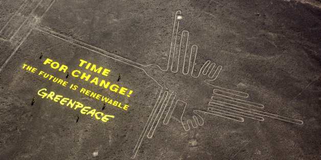 Greenpeace activists stand next to massive letters delivering the message "Time for Change: The Future is Renewable" next to the hummingbird geoglyph in Nazca in Peru, Monday, Dec. 8, 2014. Greenpeace activists from Brazil, Argentina, Chile, Spain, Germany, Italy and Austria displayed the message, which can be viewed from the sky, during the climate talks in Peru, to honor the Nazca people, whose ancient geoglyphs are one of the country's cultural landmarks. (AP Photo/Rodrigo Abd)