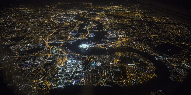 LONDON, ENGLAND - MAY 20: An aerial view of the buildings and streets of London, including the O2 Arena and the Canary Wharf development on the Isle of Dogs, which are illuminated at night on May 20, 2014 in London, England. (Photo by Oli Scarff/Getty Images)