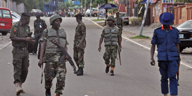 Nigerian soldiers patrol the area, near the scene of an explosion in Abuja, Nigeria, Wednesday, June 25, 2014. An explosion rocked a shopping mall in Nigeria's capital, Abuja, on Wednesday and police say at least over 20 people have been killed and many wounded. Witnesses say body parts were scattered around the exit to Emab Plaza, in the upscale Wuse 11 suburb. (AP Photo/Olamikan Gbemiga)