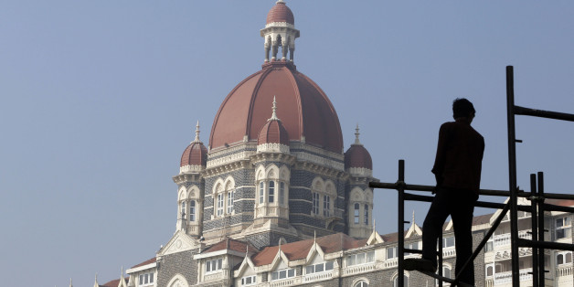 An Indian worker prepares a stage outside the Taj Mahal Hotel, one of the sites of the Mumbai terror attack, for an event to mark the 5th anniversary of the attack in Mumbai, India, Saturday, Nov. 26, 2013. Pakistani gunmen blazed through India's financial capital on Nov. 26, 2008, killing 166 people and shattering relations between the nuclear-armed neighbors. (AP Photo/Rajanish Kakade)