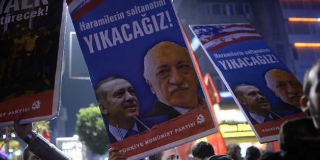 A Turkish protester holds up a placard with pictures of Turkish Prime Minister Recep Tayyip Erdogan (L) and the United States-based Turkish cleric Fethullah Gulen reading 'We will cast them down' during a demonstration against corruption in the Kadikoy district of Istanbul on December 25, 2013. Turkish Prime Minister Recep Tayyip Erdogan replaced nearly half his cabinet in a dramatic reshuffle late on December 25 after a spreading graft scandal forced the resignation of three top ministers and t