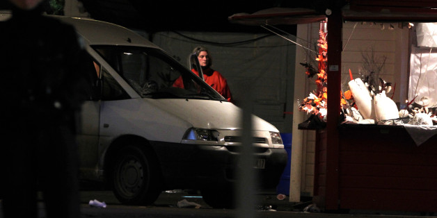 A police officer stands by the van that crashed into a French Christmas market in Nantes, western France, Monday, Dec.22, 2014. French authorities urged calm after a series of attacks across the country left dozens of people injured, and said there was no evidence the attacks were connected by any terrorist motive. In the latest incident, 11 people were injured after a driver crashed his van into a crowded Christmas market in western France Monday evening. The driver then stabbed himself several times and is among five people hospitalized in serious condition, authorities said. (AP Photo/Laetitia Notarianni)