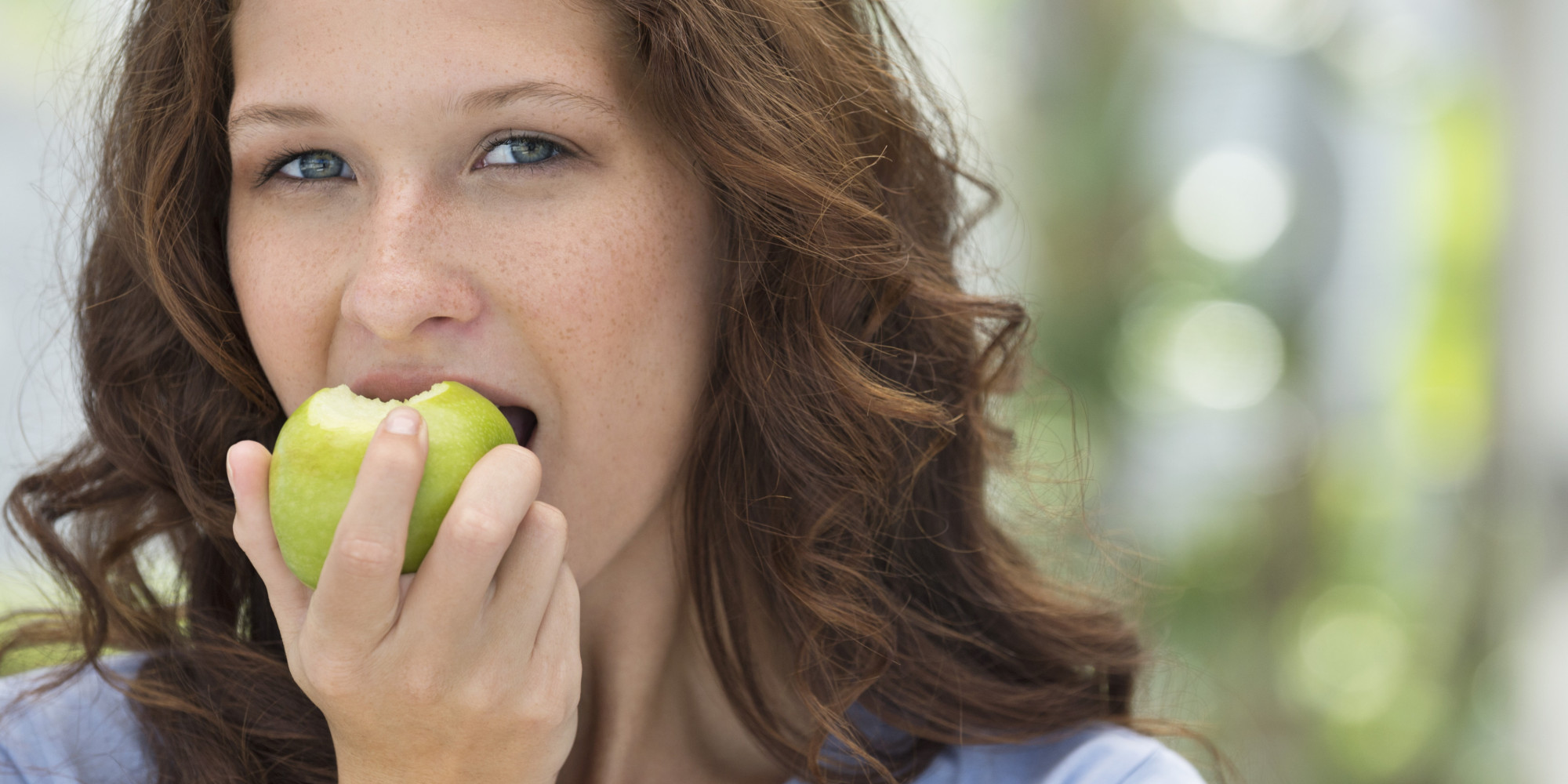 She eats apples. Женщина с яблоком. Улыбающаяся девушка с зеленым яблоком. Фотосессия с зелеными яблоками. Фото девушки с зелеными яблоками.