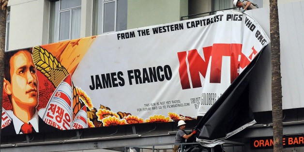 Workers remove a poster for 'The Interview' from a billboard in Hollywood, California, December 18, 2014 a day after Sony announced it had no choice but to cancel the movie's Christmas release and pull it from theaters due to a credible threat. Sony defended itself Thursday against a flood of criticism for canceling the movie which angered North Korea and triggered a massive cyber-attack, as the crisis took a wider diplomatic turn. AFP PHOTO / MICHAEL THURSTON (Photo credit should read