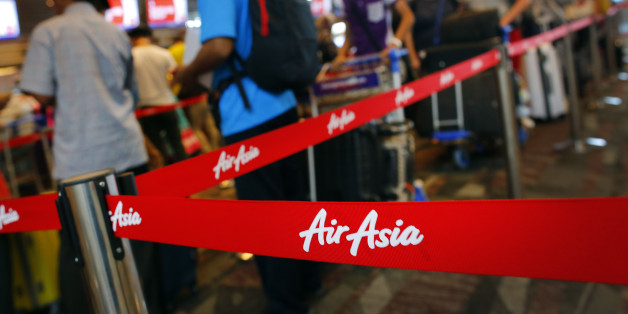 Passengers queue at AirAsia's check-in counters, at the Changi International Airport Monday, Dec. 29, 2014 in Singapore. Search planes and ships from several countries on Monday were scouring Indonesian waters over which an AirAsia jet disappeared, more than a day into the region's latest aviation mystery. AirAsia Flight 8501 vanished Sunday in airspace thick with storm clouds on its way from Surabaya, Indonesia, to Singapore. (AP Photo/Wong Maye-E)
