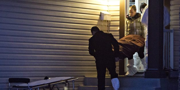 The body of a victim is carried out of a north Edmonton home in Edmonton, Alberta, Tuesday, Dec. 30, 2014. Nine people, including seven adults and two young children, were found dead at three separate crime scenes in what Edmonton's police chief on Tuesday called a "senseless mass murder." (AP Photo/The Canadian Press, Jason Franson)