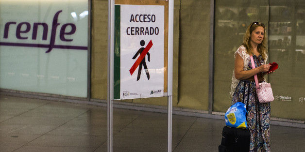 A passenger passes a sign reading 'Closed Access', as she arrives at Atocha train station during a partial train strike, in Madrid, Spain, Thursday, July 31, 2014. Spanish train workers have begun a nationwide strike as one of the country's busiest holiday periods kicks off. Workers for the state train company Renfe and rail infrastructure firm Adif began the strike Thursday to protest staff shortages and company plans to privatize certain operations. (AP Photo/Andres Kudacki)