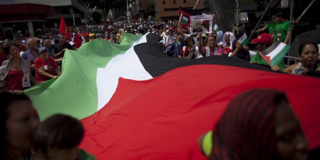Venezuelans march with a large Palestinian flag during a government organized demonstration in support of the Palestinian people and against Israel's offensive in Gaza, in Caracas, Venezuela, Saturday, Aug. 2, 2014. (AP Photo/Ariana Cubillos)