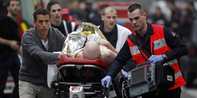 An injured person is evacuated outside the French satirical newspaper Charlie Hebdo's office, in Paris, Wednesday, Jan. 7, 2015. Police official says 11 dead in shooting at the French satirical newspaper. (AP Photo/Thibault Camus)